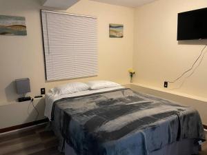 a bedroom with a bed and a flat screen tv at ~Como's Finest ~A Home Away From Home ~Sleeps 10 ~ in Columbia