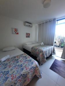 een hotelkamer met 2 bedden en een raam bij Imbassaí Solaris Ap Beach in Imbassai
