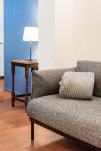 un sofá en una habitación con una mesa y una lámpara en La casa di Ugo-a due passi dal Duomo, en Florencia