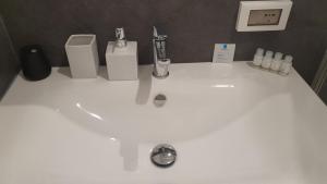 a bathroom sink with a white counter top with soap dispensers at Appartamenti Reali Bonaccini in Milan