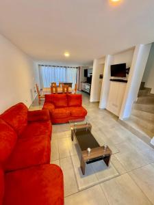 sala de estar con sofá rojo y mesa en Casa en Fraccionamiento Privado con alberca, en Cuautlancingo