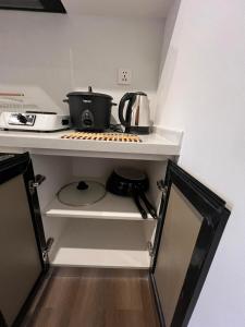 a kitchen with a counter with a pot on a shelf at CASA JBL Megatower 4 in Baguio