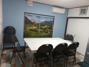 una sala de reuniones con mesa blanca y sillas en Mike's B&B Tokoname, en Tokoname