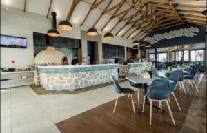 ein Restaurant mit Tischen und Stühlen und eine Bar in der Unterkunft 362@BallitoHills in Ballito