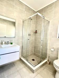 a bathroom with a shower with a sink and a toilet at 362@BallitoHills in Ballito
