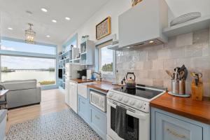 cocina con electrodomésticos blancos y ventana grande en Tillamook Bayfront Cottage - Amazing Views - Garibaldi, en Garibaldi