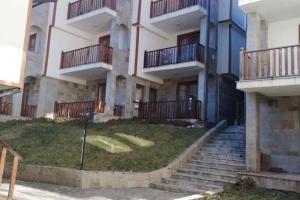 an apartment building with stairs in front of it at Апартамент 9 in Pamporovo