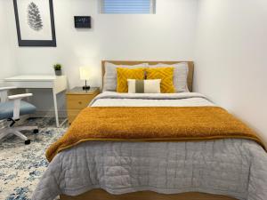 a bedroom with a bed with yellow pillows and a desk at Whitby Private Rooms in Whitby