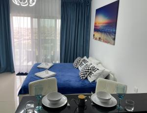 um quarto com uma cama azul, uma mesa e cadeiras em Great view, Dubai SportCity, parking included, nice Apartments em Dubai