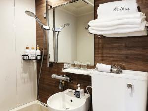 a bathroom with a shower and a toilet and a sink at Le Tour Hotel Akihabara Kanda 楽途ホテル神田秋葉原 in Tokyo