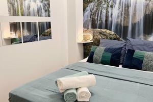 ein Schlafzimmer mit einem Bett mit Handtüchern darauf in der Unterkunft Le petit cocon de Kintana / Disney/Paris/JO in Meaux