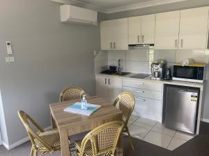 a kitchen with a table and chairs and a kitchen with a microwave at Central Oasis in Coffs Harbour