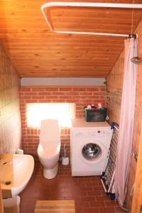 a small bathroom with a toilet and a washing machine at Summerhouse Near The Limfjord And The Western Sea in Vestervig