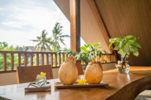 a wooden table with two vases on top of it at The Vinaya Boutique Hotel in Ubud