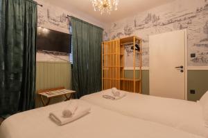 2 łóżka w pokoju z zielonymi zasłonami w obiekcie MrGolinski w Dubrowniku