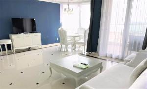 a living room with a white couch and a table at Ocean Star Condominium in Seogwipo