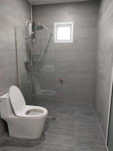 a bathroom with a toilet and a glass shower at Nongnuchs Homestay Queen Bed in San Sai