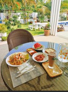 a table with plates of food and drinks on it at Nongnuchs Homestay Queen Bed in San Sai