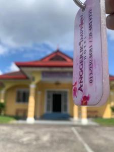 uma garrafa de vinho em frente a uma casa em ANGGERIK IMPIAN HOTEL -Best for Travellers at Kuala Berang em Kuala Berang