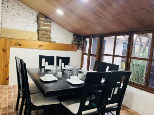 a dining room with a black table and chairs at Casa en el centro de San Cristóbal in San Cristóbal de Las Casas