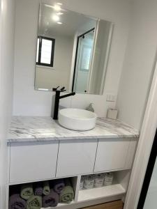 a white bathroom with a sink and a mirror at Tiny Home + Donkeys + Alpacas in Tamborine