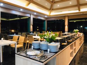 a buffet line with plates and dishes on it in a restaurant at Mayflower Grande Suite Hotel in Phitsanulok