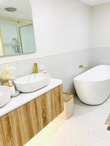 a bathroom with two sinks and a tub at Deluxe Queen Studio Fully Self Contained- Living, kitchenette, laundry, bedroom, bathroom, parking, Wifi, - Free shuttle Service in Gold Coast