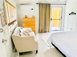 a bedroom with a bed and a chair and a window at Deluxe Queen Studio Fully Self Contained- Living, kitchenette, laundry, bedroom, bathroom, parking, Wifi, - Free shuttle Service in Gold Coast