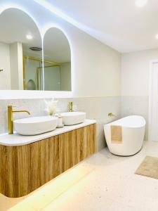 een badkamer met 2 wastafels en een bad bij Deluxe Queen Studio Fully Self Contained- Living, kitchenette, laundry, bedroom, bathroom, parking, Wifi, - Free shuttle Service in Gold Coast