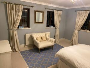 sypialnia z krzesłem, łóżkiem i oknami w obiekcie Maple House 