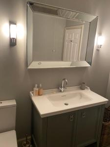 uma casa de banho com um lavatório e um espelho em Maple House 