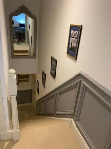a hallway with a stairway with a mirror on the wall at Maple House 