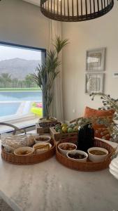 a table with baskets of fruits and vegetables on it at Sheema Lodge in Hatta