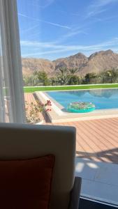 a view of a swimming pool from a living room at Sheema Lodge in Hatta