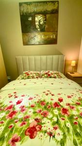 a bed with red flowers on it with a painting at B&B Jacqmain in Brussels