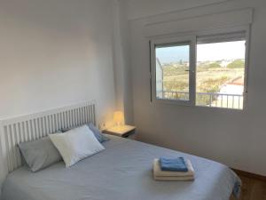 Un dormitorio blanco con una cama con ventana. en Renovated and Cozy Apartment, en Mareny Blau