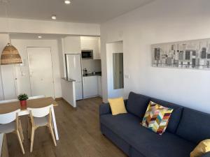 Una sala de estar con un sofá azul y una mesa. en Renovated and Cozy Apartment, en Mareny Blau