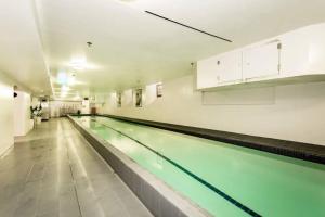 a large swimming pool in a large room at Historic Apartment - Cathedral Square CBD in Christchurch