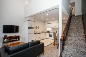 a living room with a couch and a kitchen at Historic Apartment - Cathedral Square CBD in Christchurch