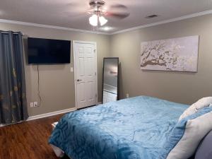 a bedroom with a bed and a flat screen tv at Welcome to Cozy and Quiet Residence in Valdosta