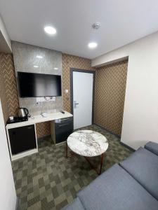 a room with a couch and a table and a desk at FLORYA EXPRESS APART in Istanbul