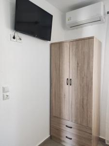 a wooden cabinet with a tv on a wall at Dolphins House in Kinira