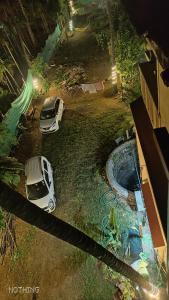 two cars parked in a yard next to a pool at Mauli Cottage in Kashid