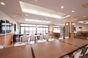 a conference room with a large table and chairs at 鹿島アイビーホテル in Fukashiba