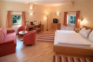 a bedroom with a bed and a desk and chairs at Gasthof Schorn in Sankt Leonhard
