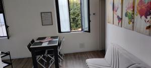 Habitación con escritorio, silla y ventana. en Lago Maggiore Lake Me Home apartment en Sesto Calende
