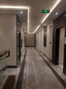 an empty hallway in a building with a sign on the ceiling at Al Azmy Al Ared Hotel in Riyadh