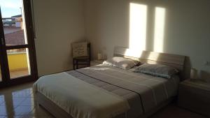a bedroom with a large bed with a large window at Sa Ziminera in Senorbì