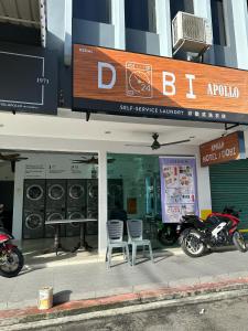 a store with two chairs and a motorcycle in the window at HOTEL APOLLO KAMPUNG BENGGALI in Butterworth