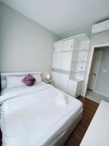 a bedroom with a large white bed with a purple pillow at Masteri An Phu - Condo 1-2BR Apartment with Pool GYM D2 in Ho Chi Minh City